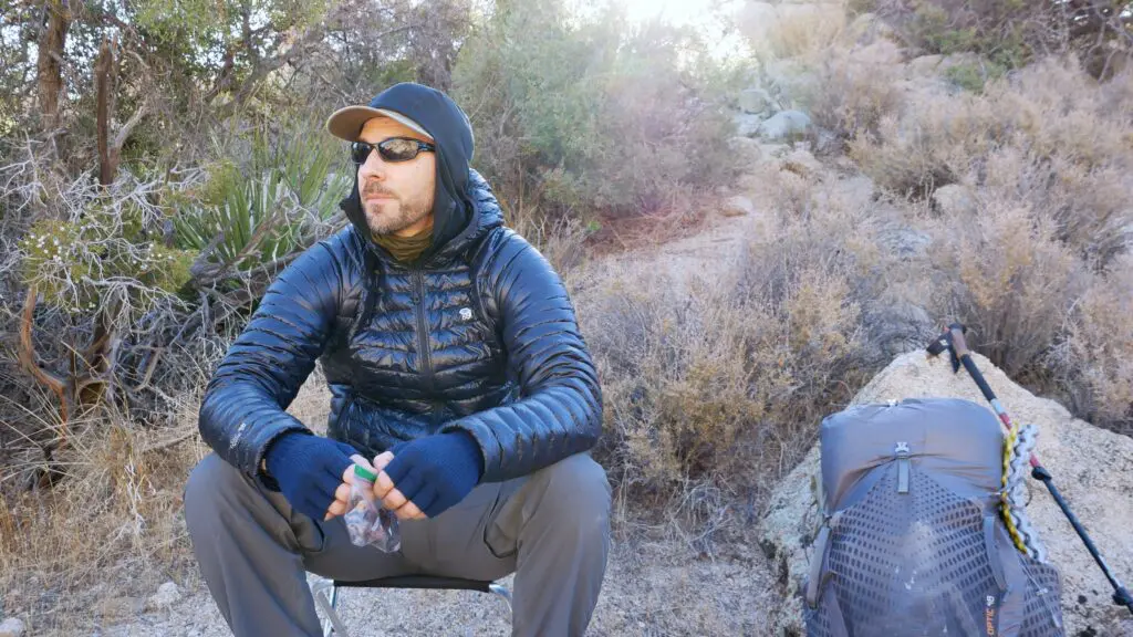 backpacker-sitting-on-camp-stool A backpacker sitting on the Stansport folding camp stool while taking a break and eating a snack on the trail.
