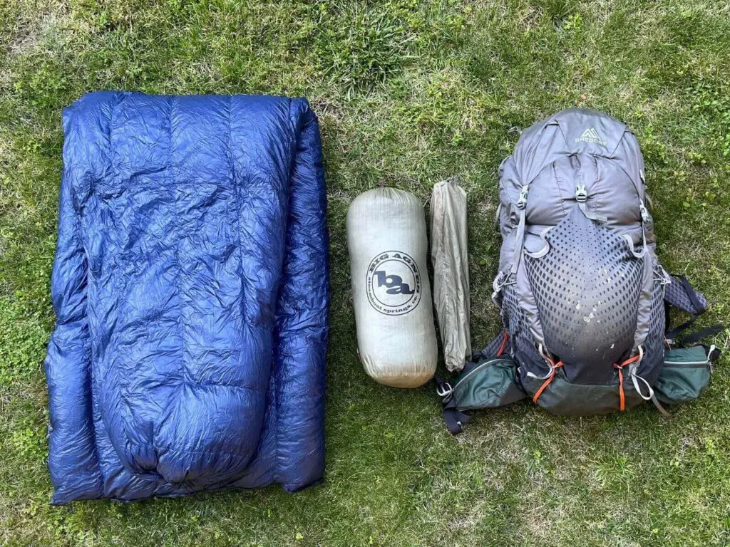 beginner-backpacking-big-3-gear-layout Beginner backpacking gear flat lay showing sleep system, tent, and pack—known as the Big Three essentials.