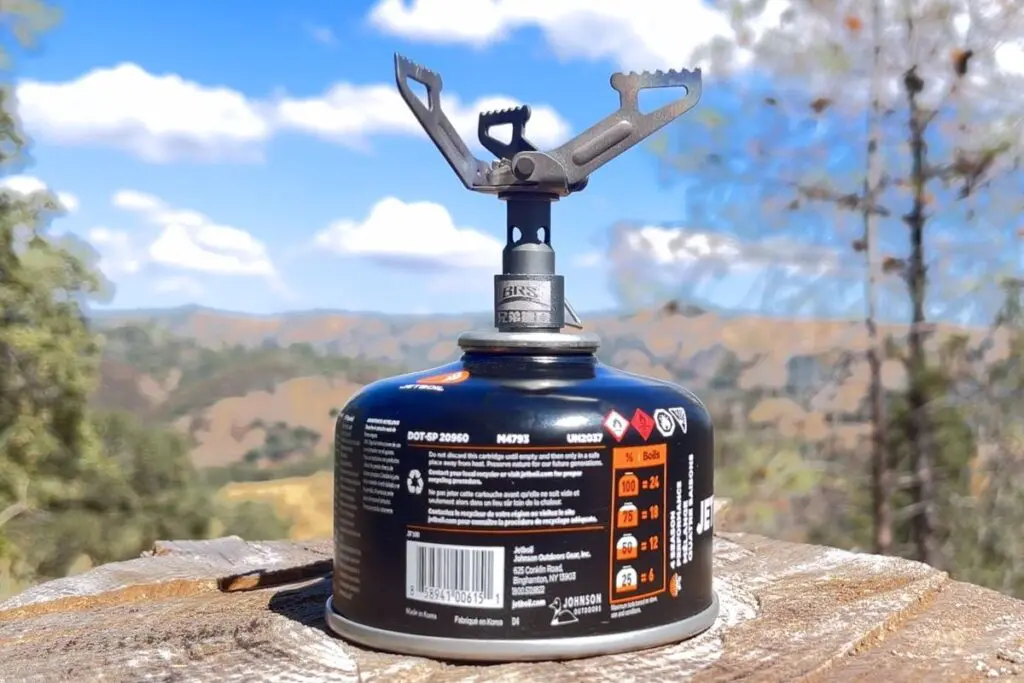 brs-3000t-backpacking-stove BRS-3000T ultralight backpacking stove mounted on a fuel canister with oak foothills in the background.