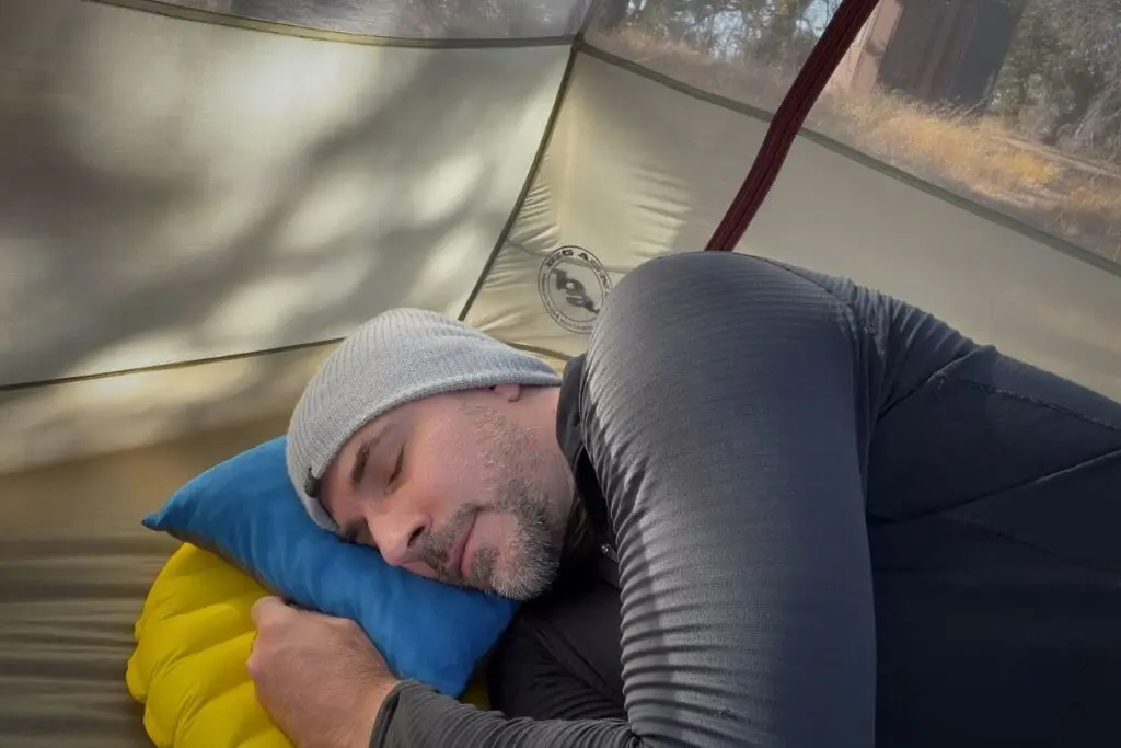 backpacking-sleep-pad-side-sleeping Side sleeper sleeping with head on a small inflatable pillow inside a backpacking tent