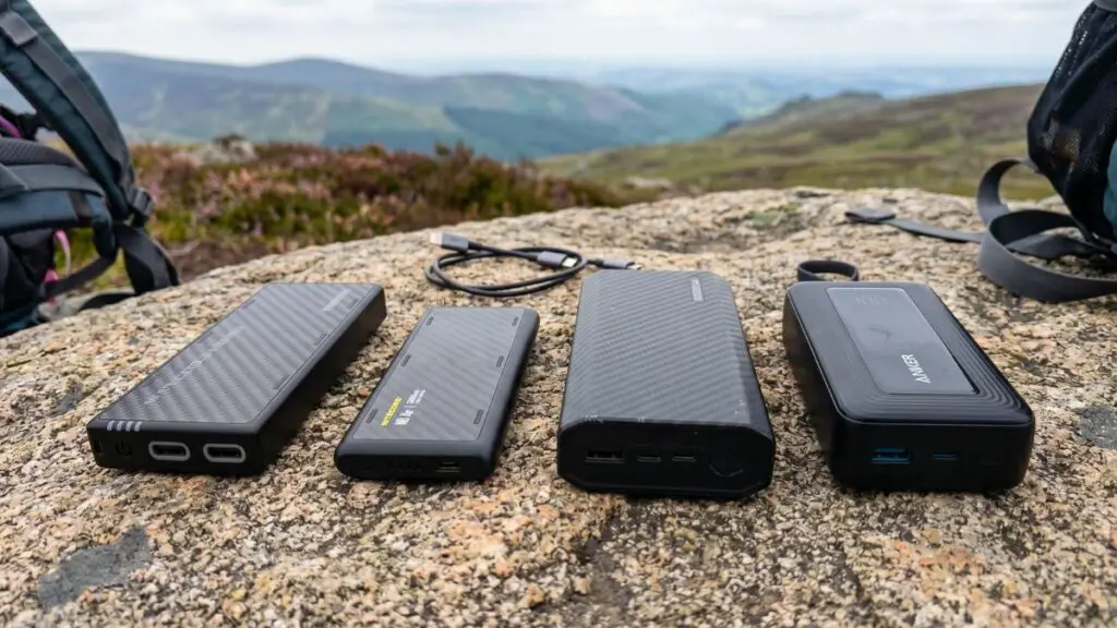 backpacking-power-banks-on-rock-in-backcountry Four backpacking power banks lined up on a granite rock with mountains in the background