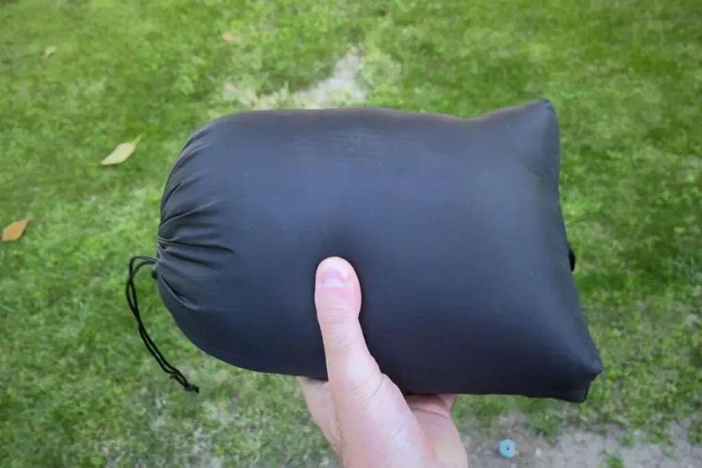ultralight-backpacking-quilt-in-stuff-sack Hand holding the Enlightened Equipment Revelation backpacking quilt packed into its stuff sack.