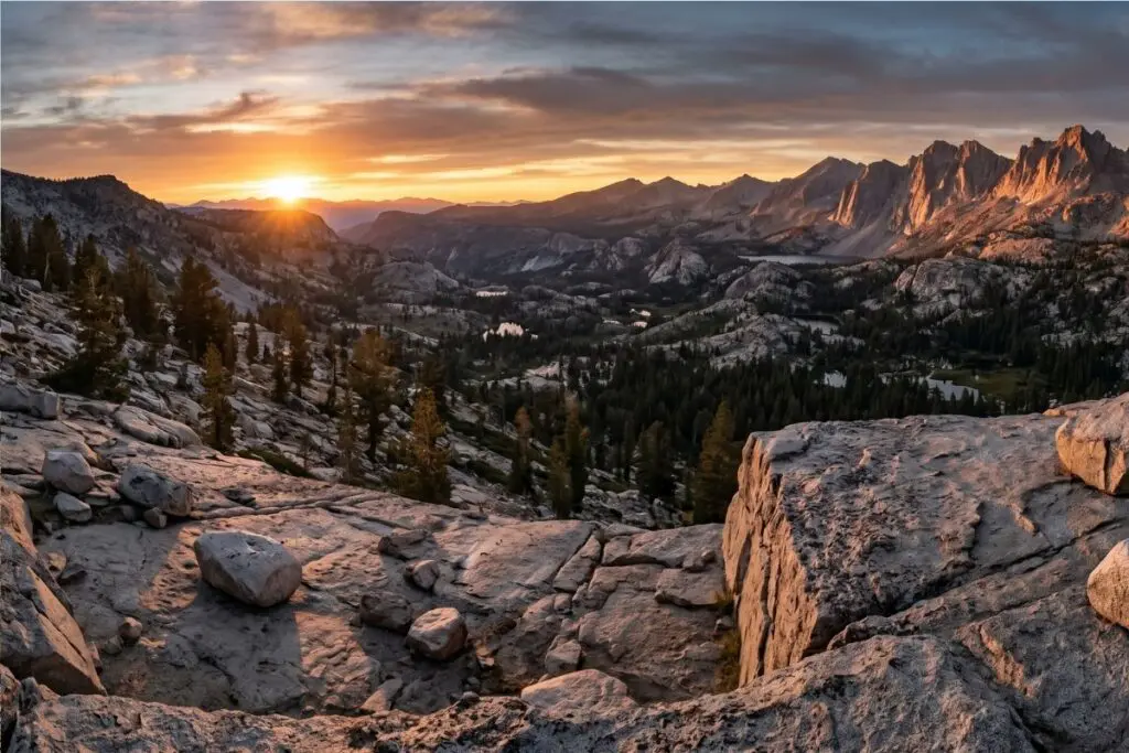 high-sierra-ridge-overlook-sunset Sun setting over a High Sierra ridgeline and forested valley from a granite overlook at the end of a backpacking day